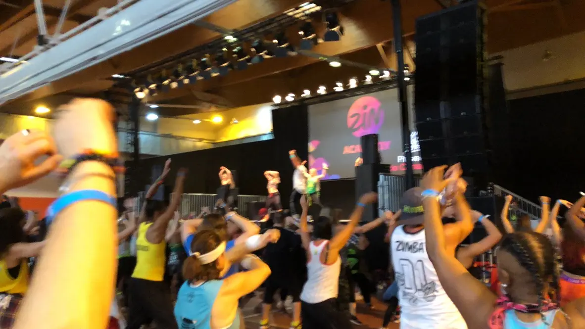 Participants dansant devant une scène lors d’un événement Zumba